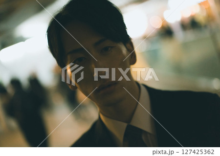 残業続きで夜遅い帰宅になった会社員 127425362