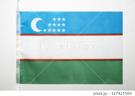 Closeup view of the Uzbekistan Republic national flag isolated over a white background. Concept of government and nationality 127425560