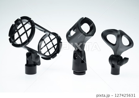Collection set of black adjustable microphone mount for studio setting isolated over white background Collection set of black adjustable microphone mount for studio setting isolated over white background 127425631