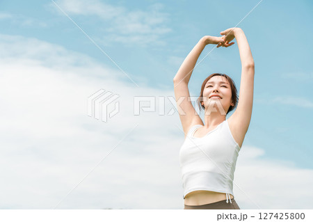 青空の下でストレッチするヨガウェアの女性(運動・深呼吸・日光浴・リフレッシュ・ストレス解消) 青空の下でストレッチするヨガウェアの女性(運動・深呼吸・日光浴・リフレッシュ・ストレス解消) 127425800