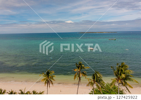 Top view of tropical island with palm trees. Ocean waves on sandy beach in Bantayan Island, Cebu, Philippines. Top view of tropical island with palm trees. Ocean waves on sandy beach in Bantayan Island, Cebu, Philippines. 127425922