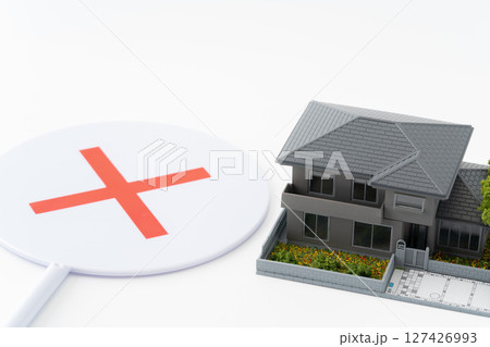 白背景にミニチュアの一戸建ての家とバツのプレート 127426993