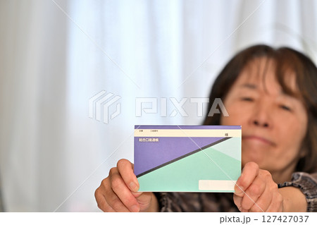 預金通帳 貯金通帳の残高を確認し安心するシニア 127427037