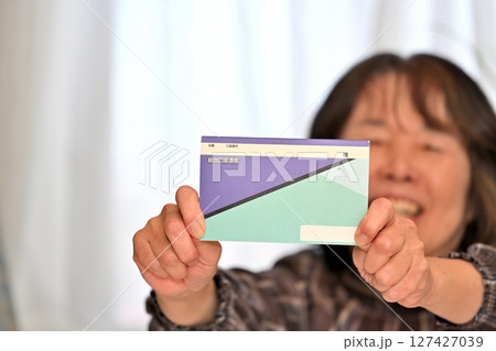 預金通帳 貯金通帳の残高を確認し喜ぶシニア 預金通帳 貯金通帳の残高を確認し喜ぶシニア 127427039