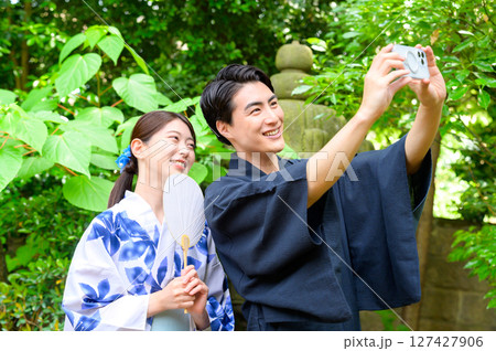 浴衣姿の男女がスマートフォンを手に満面の笑みで自撮りをする思い出に残る夏の午後の一枚 浴衣姿の男女がスマートフォンを手に満面の笑みで自撮りをする思い出に残る夏の午後の一枚 127427906