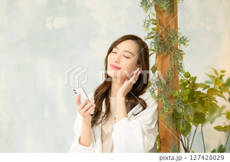スマホで音楽を聴く女性 127428029