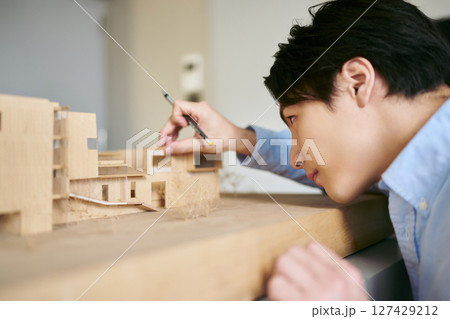 大学の工学部の建築学科で建物の模型を見てクリエイティブな思考を持って建築の課題を設計する学生 大学の工学部の建築学科で建物の模型を見てクリエイティブな思考を持って建築の課題を設計する学生 127429212