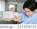 建築の模型を作って戸建て住宅の設計を勉強する美術大学で学ぶ男性の学生 建築の模型を作って戸建て住宅の設計を勉強する美術大学で学ぶ男性の学生 127429219