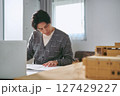 建築を設計する事務所で模型と図面を前に真剣に働く建築士の1人の男性 建築を設計する事務所で模型と図面を前に真剣に働く建築士の1人の男性 127429227
