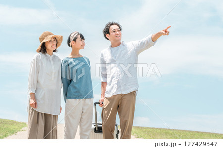 青空の下にいる3人の親子（家族旅行,ファミリー,父親,母親,娘） 127429347