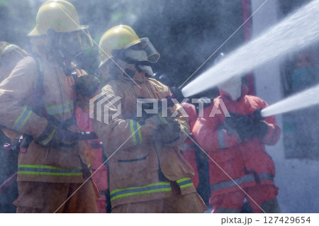 Teams of Firefighters Spray Water to Tame the Fire 127429654