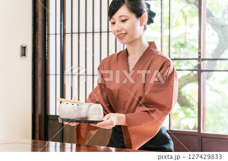 旅館,料亭で日本茶を運ぶ女性スタッフ,仲居,女将 127429833