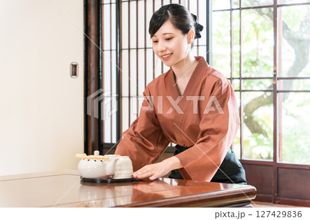 旅館,料亭で日本茶を運ぶ女性スタッフ,仲居,女将 127429836
