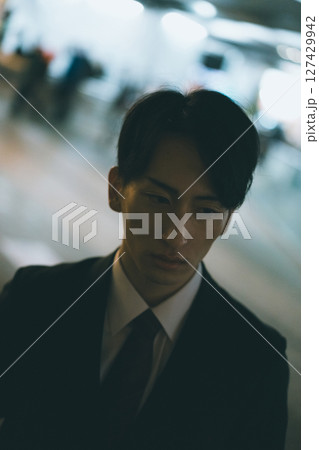 家路を急ぐ若い男性ビジネスパーソンの夜 127429942