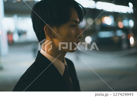 家路を急ぐ若い男性ビジネスパーソンの夜 127429945