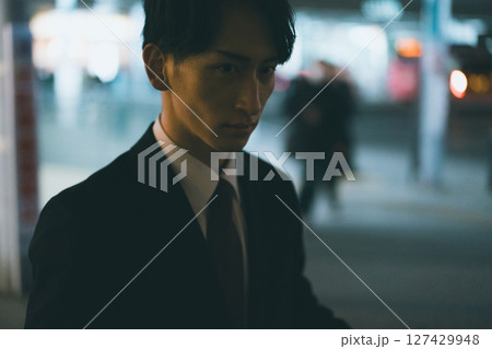 家路を急ぐ若い男性ビジネスパーソンの夜 127429948