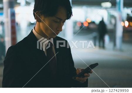 スマホを見る若い男性ビジネスパーソンの夜 スマホを見る若い男性ビジネスパーソンの夜 127429950