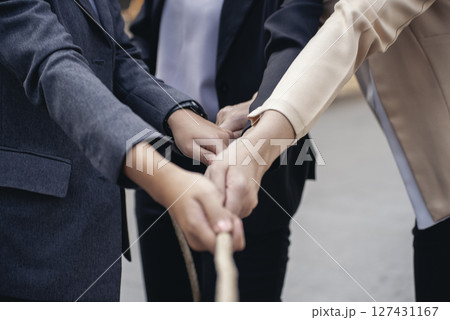 Tug of war Group of business people Hands pulling rope symbol team unified teamwork Partnership Concept. Businesswoman Team holding hands together partnership leader teamwork. diversity competition 127431167