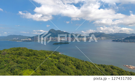 View of Forested Island Surrounded by Coastal City and Mountains View of Forested Island Surrounded by Coastal City and Mountains 127431780