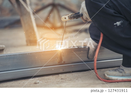 Men hands wear protective glove Hot flame metal work cutting fire iron workshop. Locksmith use Welding machine cut metal process. Construction Worker hands using Welding machinery iron metal sparking 127431911