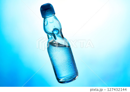 冷えたラムネ、青の背景に日本の伝統的な夏の飲み物。 冷えたラムネ、青の背景に日本の伝統的な夏の飲み物。 127432144