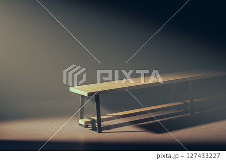 Soccer ball is sitting on the ground next to a bench 127433227