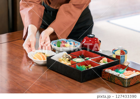 旅館,客室,個室で料理の給仕をする女性スタッフの手元 127433390