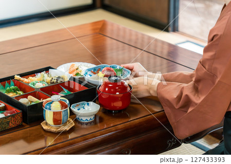 旅館,客室,個室で料理の給仕をする女性スタッフの手元 127433393