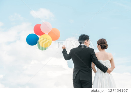 風船を持つ新郎新婦の後ろ姿(ウェディング・結婚式・ブライダル・フォトウェディング) 風船を持つ新郎新婦の後ろ姿(ウェディング・結婚式・ブライダル・フォトウェディング) 127434197