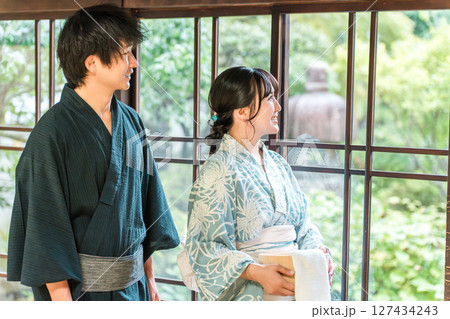 旅行で温泉旅館・宿坊・古民家の縁側を歩く浴衣姿の夫婦・カップル 127434243