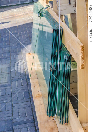 Sheets of glass stacked vertically in wooden construction frame. High quality photo Sheets of glass stacked vertically in wooden construction frame. High quality photo 127434485