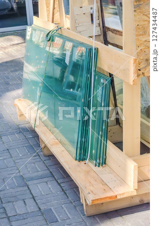 Sheets of glass stacked vertically in wooden construction frame. High quality photo 127434487