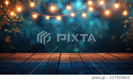 Wooden terrace illuminated by warm string lights with leafy decorations against a dark blurred evening background. Cozy outdoor setting. Night ambience. 127434803