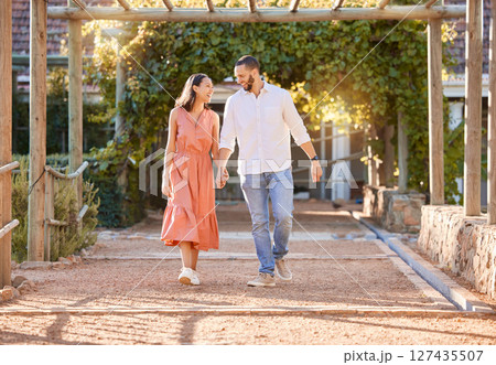 Love, date and couple holding hands in a park for trust, support and communication in summer. Happy, walking and man and woman with affection and smile on a romantic holiday after marriage in nature 127435507