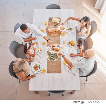 Family, lunch and food at the table with big family bonding, sharing and eating together at the dining table. Meal, top view and family home with a mother, father and grandparents and kids eat Family, lunch and food at the table with big family bonding, sharing and eating together at the dining table. Meal, top view and family home with a mother, father and grandparents and kids eat 127435508