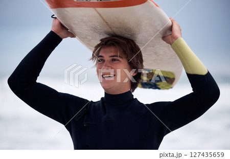 Ocean, surfer and man carrying surfboard on holiday, vacation or summer trip in Hawaii. Fitness, workout and happy male athlete with board after surfing, water sports and training exercise by sea. Ocean, surfer and man carrying surfboard on holiday, vacation or summer trip in Hawaii. Fitness, workout and happy male athlete with board after surfing, water sports and training exercise by sea. 127435659