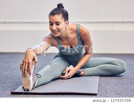 Fitness, healthcare and woman stretching legs in gym getting ready for exercise, training or workout. Sports, wellness and happy female athlete warm up in fitness center for flexibility or mobility. 127435709
