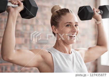 Fitness, dumbbell weights and woman training for a weightlifting exercise in the gym or studio. Sports, health and strong girl doing arm workout for strength, health and wellness at a sport center. 127435877