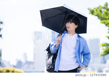 日傘をさす男性 127435990