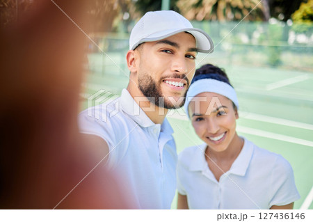 Tennis, portrait and couple take a selfie for a social media post on a social network app on a tennis court. Faces, fitness and happy woman with a smile enjoys training or workout with sportsman Tennis, portrait and couple take a selfie for a social media post on a social network app on a tennis court. Faces, fitness and happy woman with a smile enjoys training or workout with sportsman 127436146