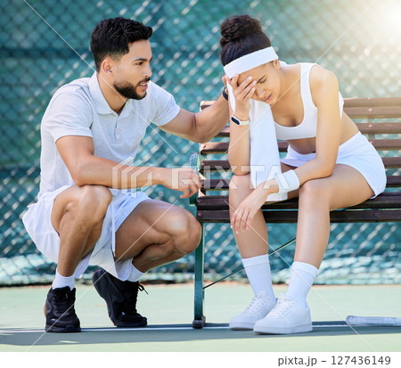 Tennis, support and loss with a sports woman feeling sad while a male athlete tries to console or comfort her. Sad, fail and loser with a young female tennis player sitting on a bench after a game Tennis, support and loss with a sports woman feeling sad while a male athlete tries to console or comfort her. Sad, fail and loser with a young female tennis player sitting on a bench after a game 127436149