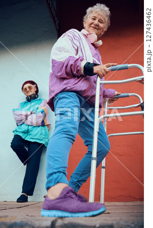 Fashion, old women and friends portrait in city on blue and red wall with stylish vintage jacket and designer shoes low angle. Retro, walking frame and retired, cool and senior females having fun. 127436462