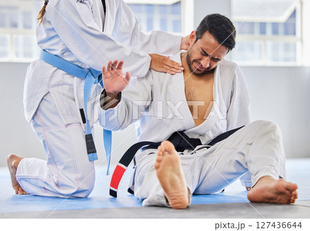 Karate, sports and neck injury pain of fighter on floor with surrender hand at professional athlete club. Accident, help and tournament of martial arts person in agony with muscle pain. Karate, sports and neck injury pain of fighter on floor with surrender hand at professional athlete club. Accident, help and tournament of martial arts person in agony with muscle pain. 127436644