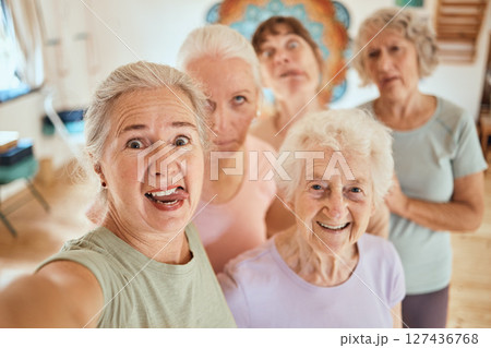 Selfie, senior women and yoga class, friends and healthy lifestyle, wellness support and fun together in exercise studio. Portrait of funny, comic and female group training happy for workout photo Selfie, senior women and yoga class, friends and healthy lifestyle, wellness support and fun together in exercise studio. Portrait of funny, comic and female group training happy for workout photo 127436768