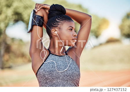 Exercise, fitness and black woman listening to music with earphones while stretching outdoor for exercise, workout and running. Female in nature for cardio with podcast for performance motivation 127437152