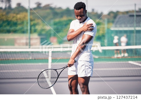 Sports, tennis and arm pain on court after training, game or match outdoors. Healthcare, tennis player and injured black man or athlete with muscle pain or inflammation after exercise or workout. Sports, tennis and arm pain on court after training, game or match outdoors. Healthcare, tennis player and injured black man or athlete with muscle pain or inflammation after exercise or workout. 127437214