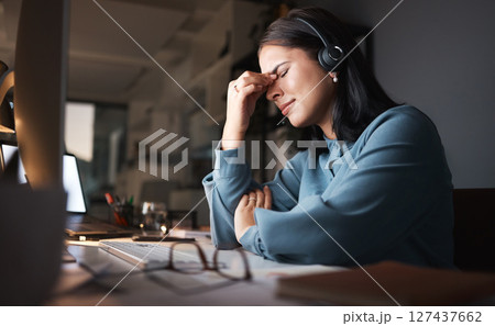 Stress, burnout and overtime, woman in call center with headache at crm office desk. Tired, frustrated and annoyed customer service consultant at computer working late at night with error or glitch. 127437662
