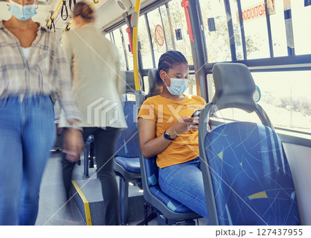 Travel, covid and woman on a bus with face mask for compliance, safety and bacteria protection in a city. Corona, public transport and girl riding busy transportation downtown during global pandemic 127437955