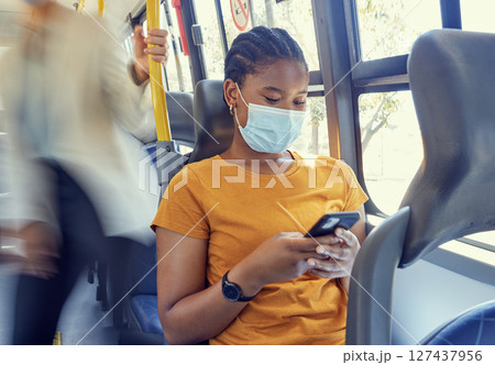 Bus travel, covid and black woman, smartphone and social media, reading notification and 5g online mobile tech on transportation. Young girl, face mask and corona virus safety with cellphone on metro Bus travel, covid and black woman, smartphone and social media, reading notification and 5g online mobile tech on transportation. Young girl, face mask and corona virus safety with cellphone on metro 127437956