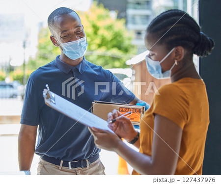 Sign, covid and black woman with a delivery at the door with a happy delivery man in a face mask for safety compliance. Ecommerce, coronavirus and African girl customer with a clipboard for a box Sign, covid and black woman with a delivery at the door with a happy delivery man in a face mask for safety compliance. Ecommerce, coronavirus and African girl customer with a clipboard for a box 127437976